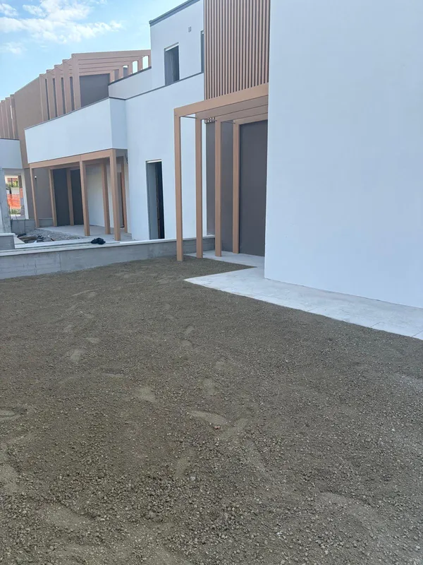 Facciate completate nei due colori con pergolati in legno e terra livellata nei giardini