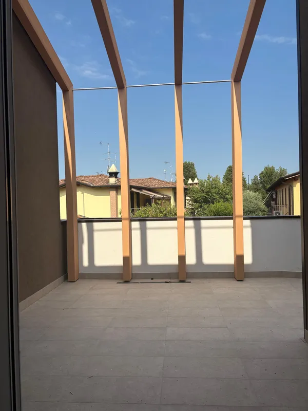 Terrazza pavimentata con pergolato in legno e parapetto finito